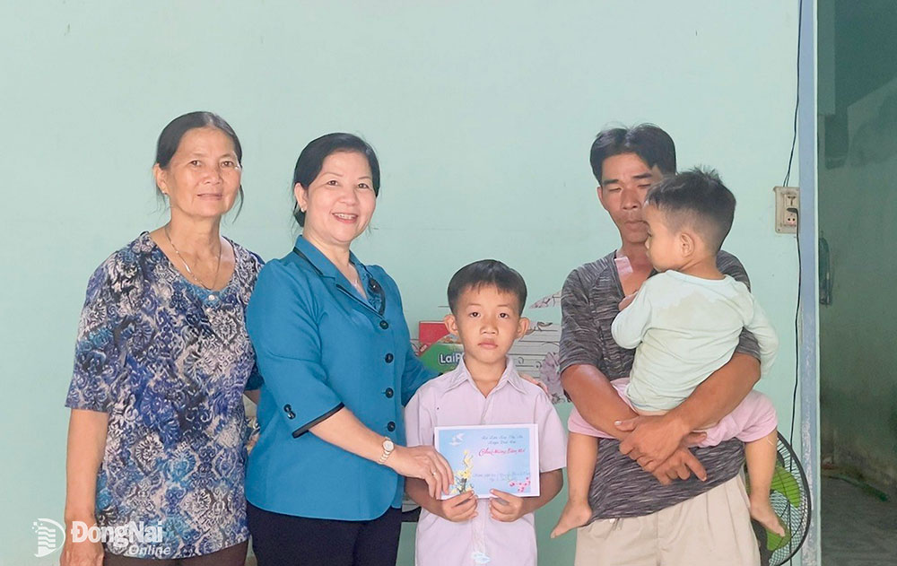 Chủ tịch Hội LHPN H.Vĩnh Cửu Trần Mỹ Ngọc (thứ 2 từ trái sang) trao hỗ trợ cho em Nguyễn Thanh Sang (ngụ ở ấp 5, xã Bình Lợi)