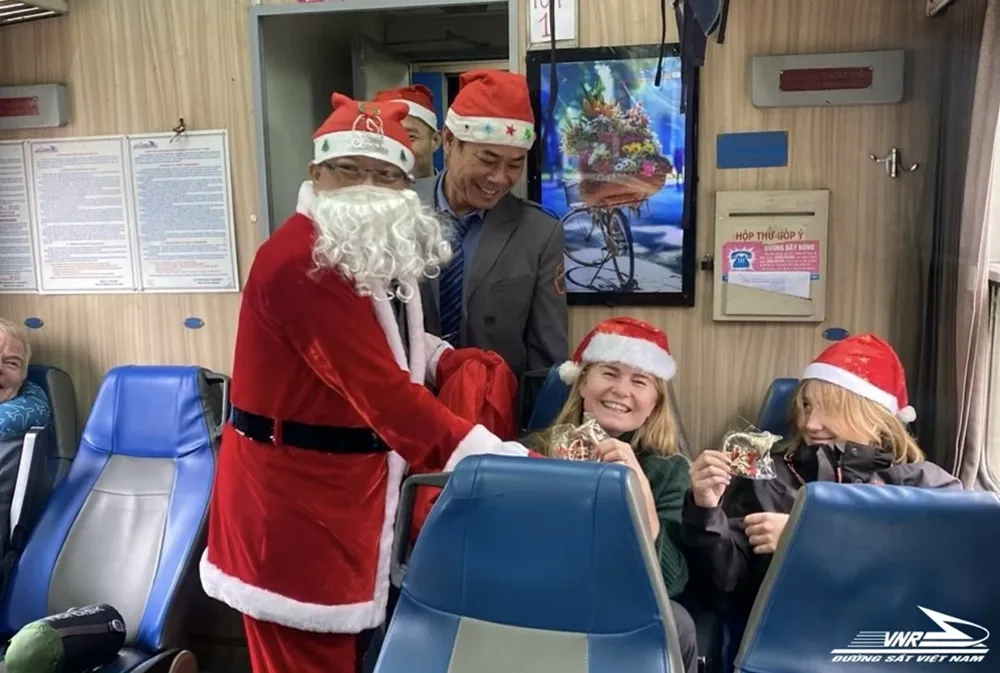 Các tiếp viên làm nhiệm vụ trên tàu đã hóa thân thành các ông già Noel để tặng các món quà Giáng sinh cho hành khách. Ảnh: CTV