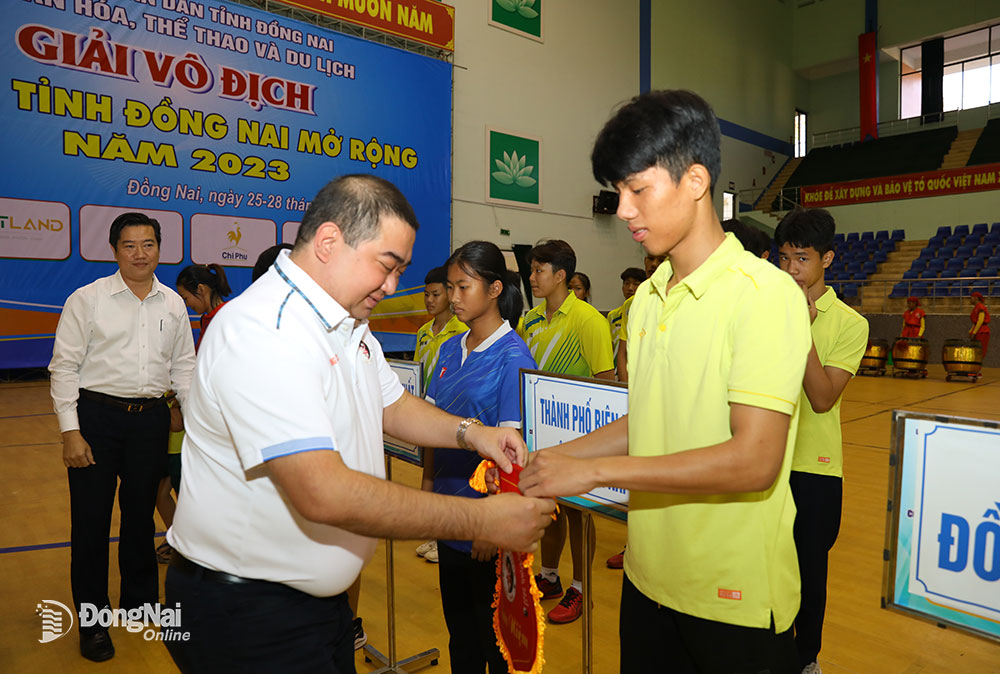 Ông Vũ Văn Trung, Trưởng Bộ môn Wushu Cục TDTT, Bộ VH-TTDL tặng cờ lưu niệm cho các đơn vị tham dự giải