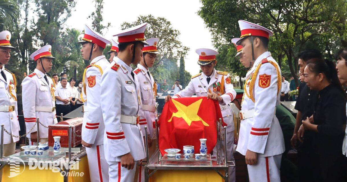 Thực hiện nghi thức án tang liệt sĩ. Ảnh: Nam Anh