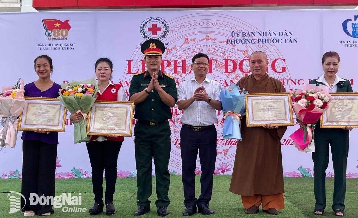 Lãnh đạo Ban Chỉ huy quân sự thành phố Biên Hòa tặng bảng tri ân các cơ quan, đơn vị, mạnh thường quân chung tay ra quân dân vận kỷ niệm 22-12. Ảnh: ĐVCC