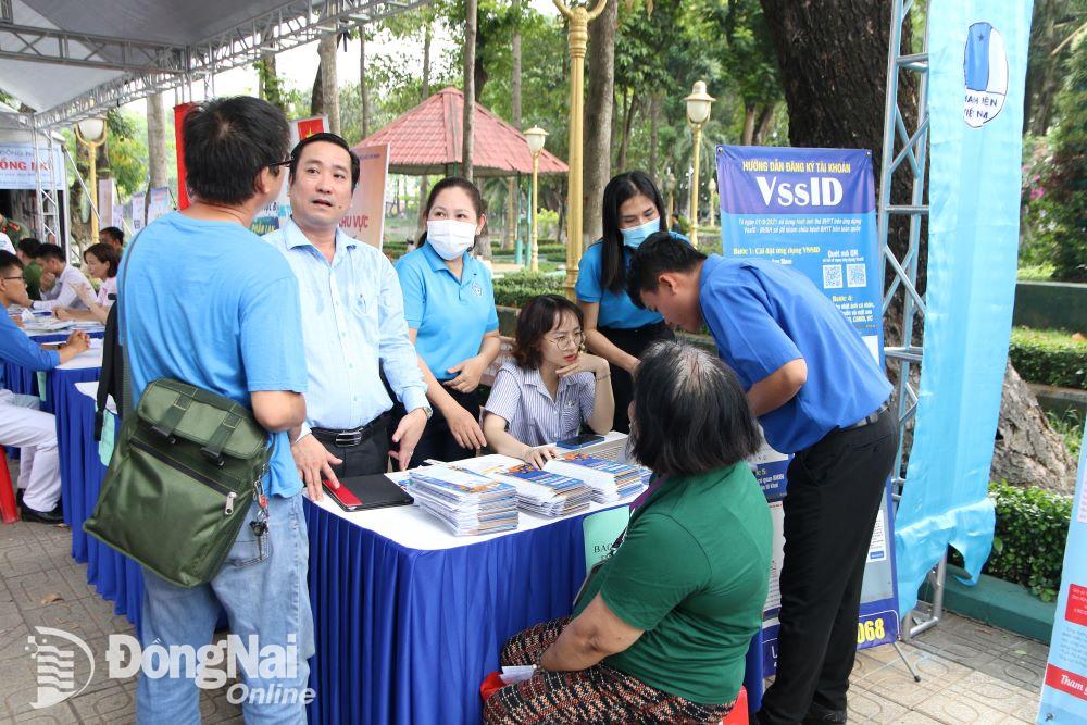 Cán bộ, nhân viên BHXH tỉnh hỗ trợ người dân cài đặt ứng dụng VssID. Ảnh: H.D