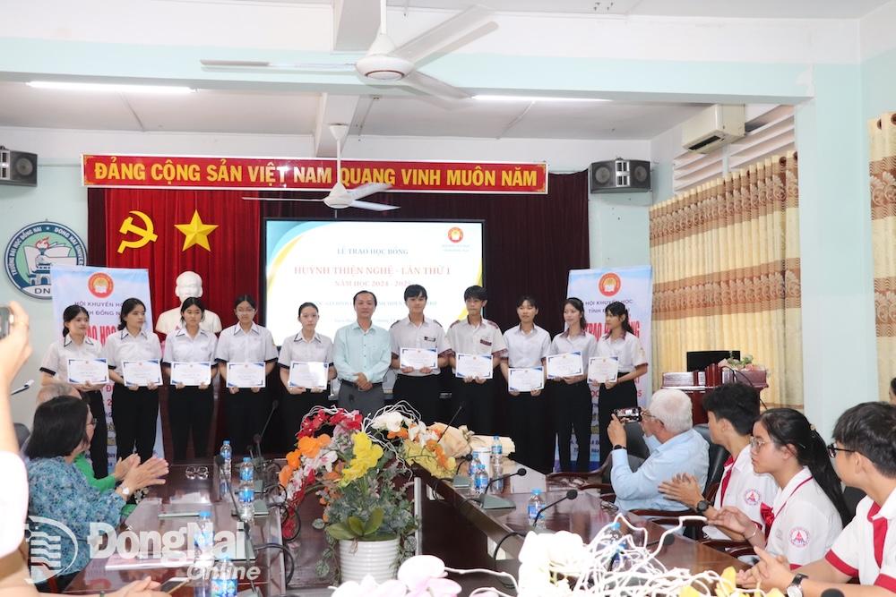 Đại diện gia đình liệt sĩ Huỳnh Thiện Nghệ trao học bổng cho các học sinh. Ảnh: Hải Yến