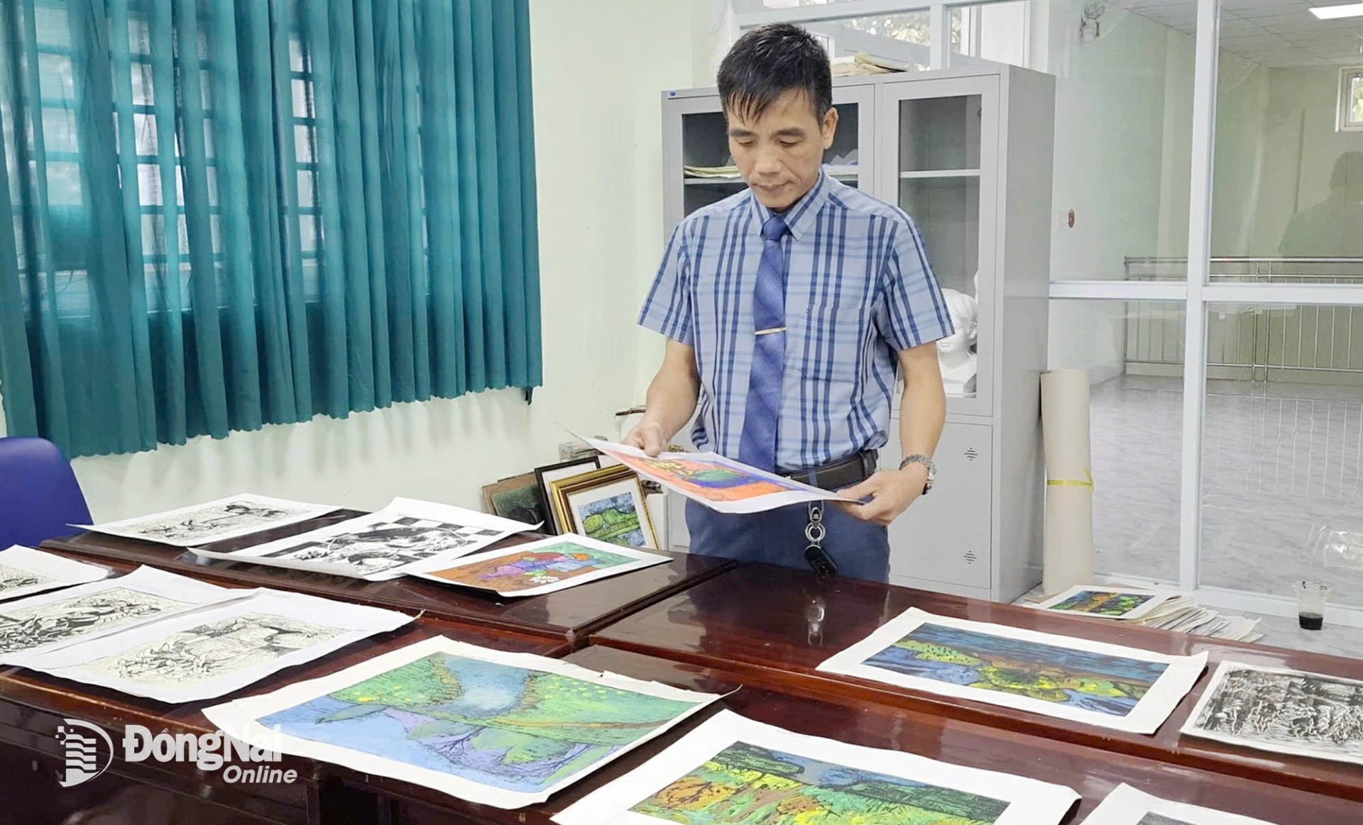 Họa sĩ - thầy giáo Nguyễn Hải Thanh xem các tác phẩm của học trò.