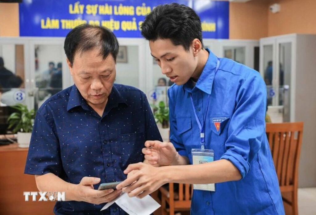 Guiding a local how to apply for administrative procedures on a mobile phone__Photo: VNA
