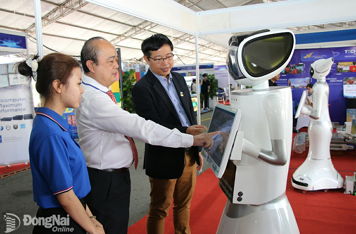 Deputy Director of the DoST Vo Hoang Khai and delegates visit an exhibition booth showcasing digital technology and innovation products at Techfest Dong Nai 2025. Photo: Hai Quan


