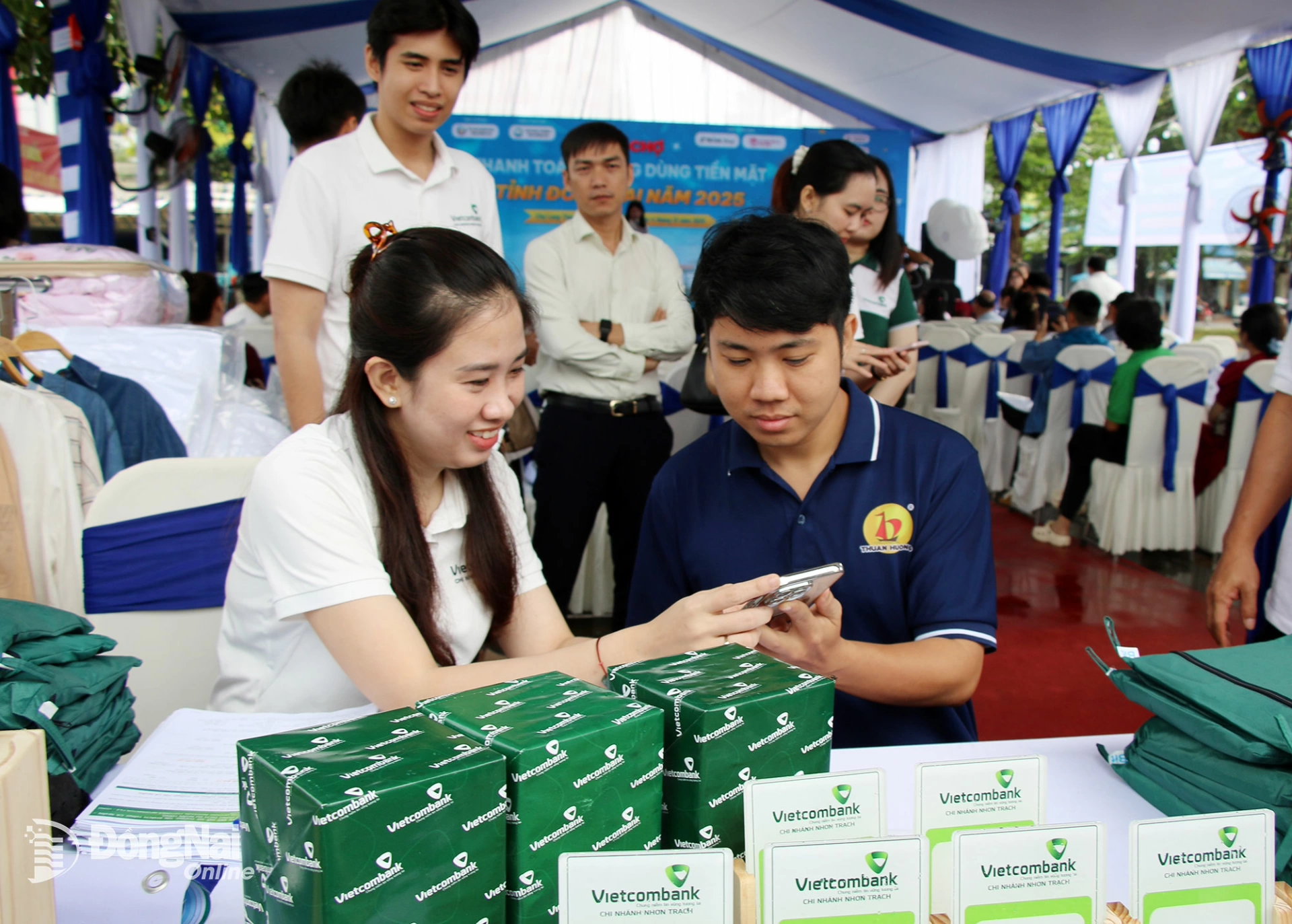 Staff from Vietcombank Nhon Trach Branch introduce and guide businesses and traders on using digital banking services at the fair. Photo: Hai Quan


