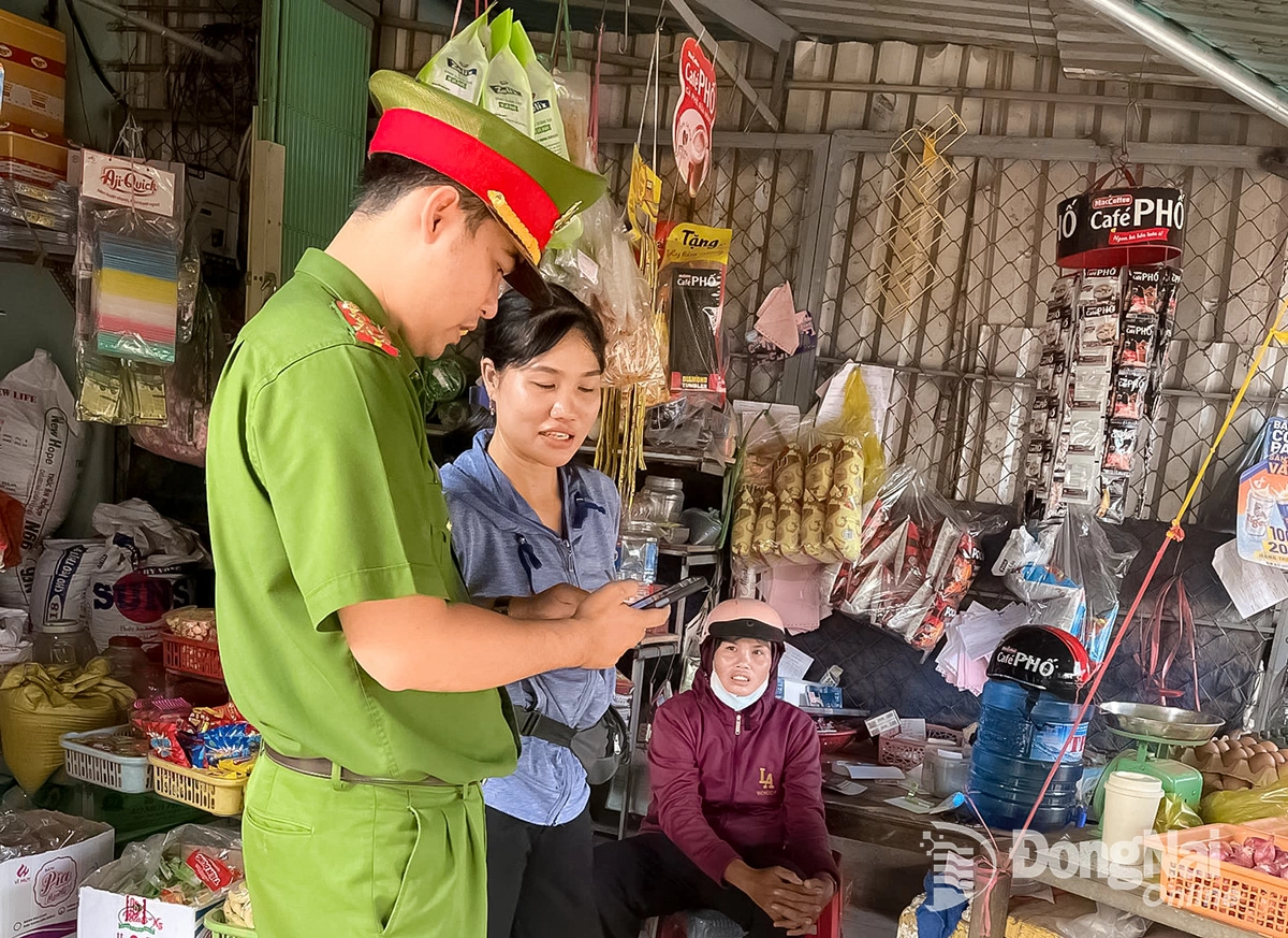 Cán bộ Công an xã Lộc Tấn đến từng nhà để hướng dẫn người dân cài đặt ứng dụng VNeTraffic. Ảnh: C.T.V