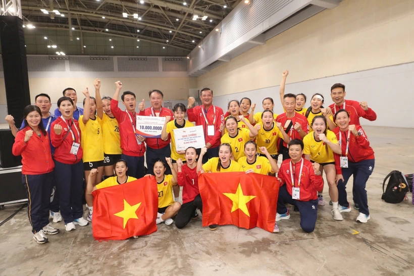 The players and coaching staff of the Vietnamese women’s handball team celebrate their SEA Games 33 gold medal. (Photo: VNA)
