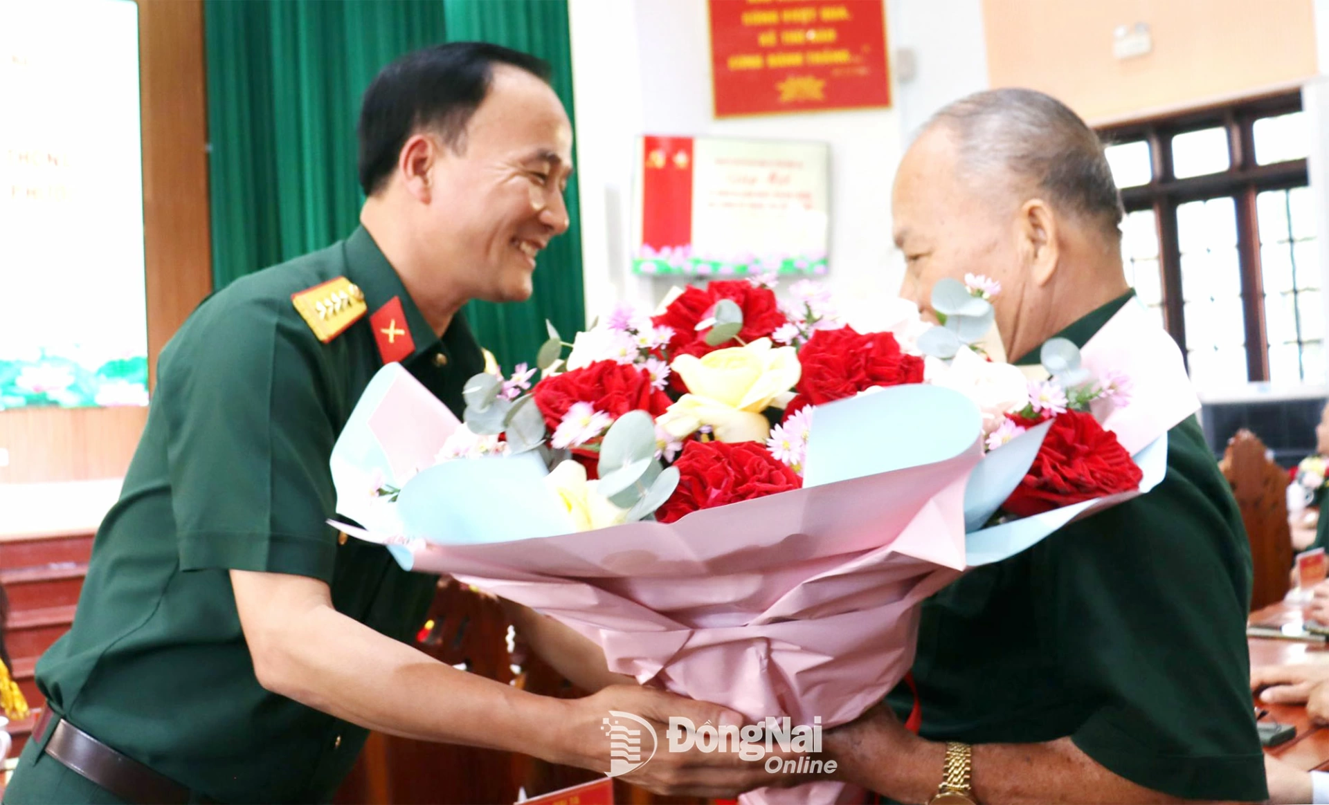 Đại tá Võ Thành Danh, Ủy viên Ban Thường vụ Tỉnh ủy, Chỉ huy trưởng Bộ Chỉ huy Quân sự tỉnh Đồng Nai tặng hoa chúc mừng Anh hùng lực lượng vũ trang nhân dân Đoàn Văn Thái. Ảnh: Nguyệt Hà