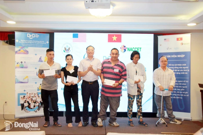 Ông Trần Đức Hùng, Phó Tổng giám đốc NACCET, Trưởng Ban quản lý Dự án Hòa nhập III-b trao vốn cho các cá nhân. Ảnh: Nga Sơn