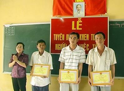 The leader of the Dinh Quan district People’s Committee awards certificates of merit for individuals for their bravery in saving five teens from drowning