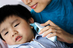 A mother uses an electronic thermometer to examine her child’s body temperature. A modern device like that would minimise the mercury poisoning risk for children. 