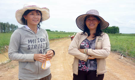 Chi Gấm (trái) và Chi hội trưởng Chi hội phụ nữ ấp trên đường khu định canh - định cư.