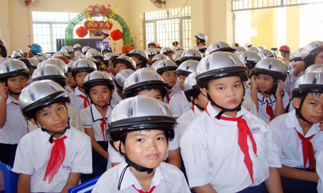 Trường tiểu học Long Bình Tân luôn chịu áp lực quá tải Trong ảnh: Học sinh của trường được tặng mũ bảo hiểm. Ảnh: B. Hường