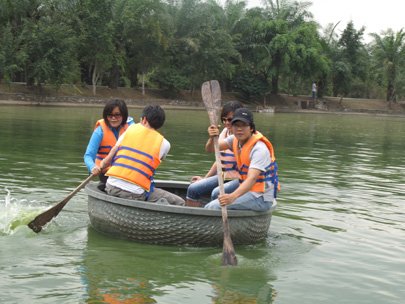 Some visitors take a bamboo boat cruise along a lake in Vuon Xoai Ecotourism Park in Dong Nai Province