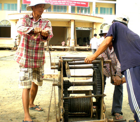 Công nhân đang dùng tời để kéo nhà đi khỏi vị trí cũ, đã kéo đi được khoảng 2m.