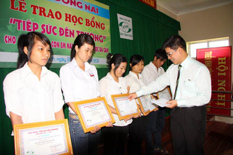 Ông Tạ Đình Chương trao học bổng cho các em học sinh.