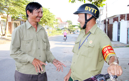 Ông Lâm Hà Bắc (trái) trao đổi công việc của tổ dân phố. Ảnh: C. NGHĨA