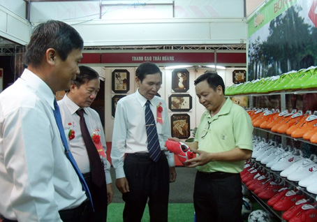 Ông Nguyễn Quang Vũ (phải) giới thiệu sản phẩm tại hội chợ làng nghề. Ảnh: B. NGUYÊN