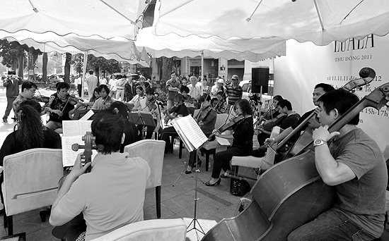 Xuan Huy and 20 stringed-instrumentalists from the Vietnam National Symphony Orchestra perform on Ly Thai To Street.