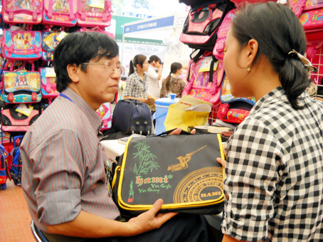 Ông Trần Bá Dũng giới thiệu sản phẩm cặp xách mới của Hami ở hội chợ hàng Việt Nam chất lượng cao tại Đồng Nai. Ảnh: B. NGUYÊN