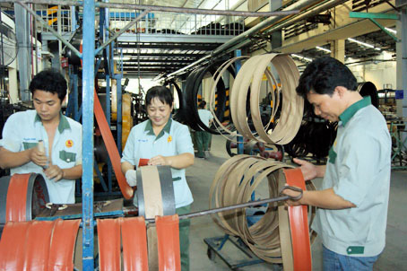 Anh Đặng Hoài Đức (phải) kiểm tra kỹ thuật trong quá trình sản xuất. Ảnh: N.Tuyết