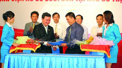 Vo Van Minh (L), general director of Long Dien Real Estate Joint Stock Co., and Nguyen Minh Chau, chairman of Me Au Co Hospital Group, exchange the signed documents of the cooperation contract last Saturday in HCMC