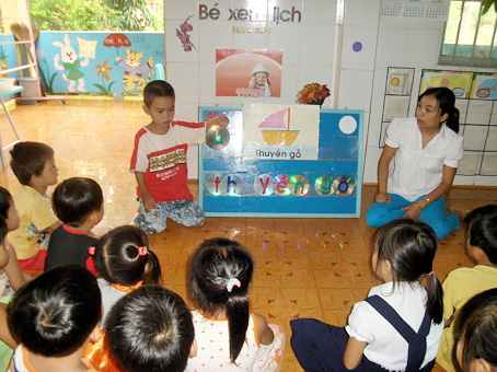 Các trẻ ở Trường mầm non Sơn Ca (huyện Cẩm Mỹ) rất thích thú với bộ đồ chơi - học tự tạo từ những chiếc dĩa CD. Ảnh: B.Hường