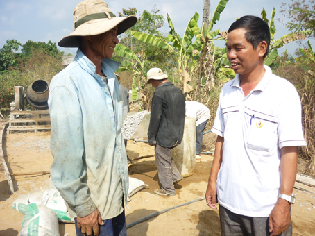 Trong quá trình làm đường, ông Hóa (phải) thường xuyên đến kiểm tra, giám sát công trình.            Ảnh: D.Quỳnh