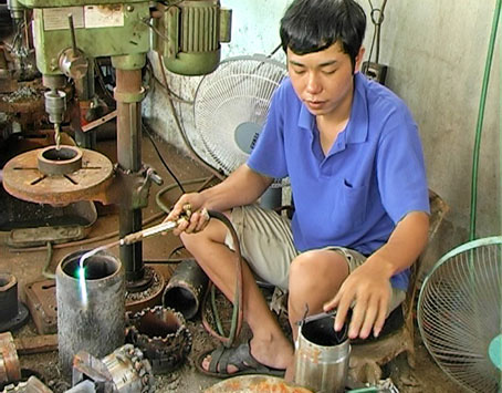 Anh Trần Minh Phụng đang làm mũi khoan giếng tại cơ sở sản xuất của mình. Ảnh: H.ĐÌNH