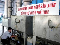 A worker gathers oil produced by recycling plastic bags April 20 at Vietnam’s first such plant in Da Nang 