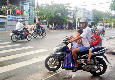 Chở con em trên xe gắn máy nhưng không trang bị phương tiện bảo hộ, sẽ gây  nguy hiểm cho trẻ.                                                                                                                                        ảnh: K.Liễu