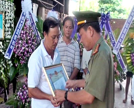 Thượng tá  Nguyễn Văn Danh trao giấy khen của Giám đốc Công an tỉnh cho gia đình anh Nguyễn Xuân Cường. Ảnh: Đ.Biên
