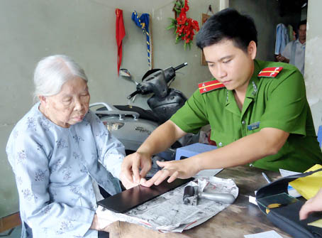 Đoàn viên Phòng PC46 làm chứng minh nhân dân cho người cao tuổi tại phường Tân Biên, TP. Biên Hòa.            Ảnh: H.Nhân