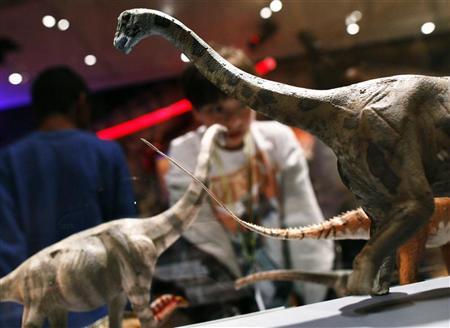 Visitors look at dinosaur replicas at ''The World's Largest Dinosaurs'' exhibit at the American Museum of Natural History in New York