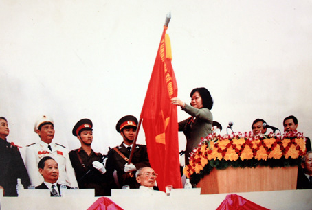 Phó chủ tịch nước Trương Mỹ Hoa gắn huy hiệu anh hùng lực lượng vũ trang nhân dân lên cờ truyền thống lực lượng vũ trang Đồng Nai.