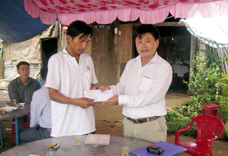 Anh Nguyễn Lê Minh, đại diện Bảo Việt Đồng Nai trao tiền cho gia đình anh Nguyễn Thanh Hoàng. Ảnh: Q.Tuyên
