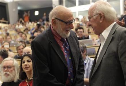 British physicist Peter Higgs (R) shakes hands with Belgium physicist Francois Englert before a scientific seminar to deliver the latest update in the search for the Higgs boson at the European 