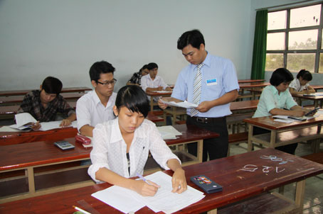 Giám thị đối chiếu hồ sơ của thí sinh trước khi phát đề tại Hội đồng thi Trường đại học Lạc Hồng chiều 9-7.
