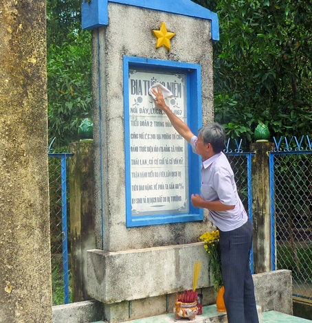 Ông Lê Thanh Hải lau chùi bia tưởng niệm liệt sĩ Đại đội 240 Nhơn Trạch hy sinh trong trận đánh đêm 20-12-1967.                 Ảnh: Đ.VIỆT