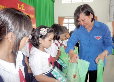 Giám đốc Nhà thiếu nhi tỉnh Nguyễn Thị Ngọc Dung trao quà cho học sinh nghèo ở huyện Định Quán.  Ảnh: N.Sơn