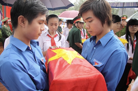 Đoàn viên thanh niên bùi ngùi xúc động đưa các liệt sĩ về nghĩa trang an nghỉ sau lễ truy điệu.  Ảnh: C.Nghĩa