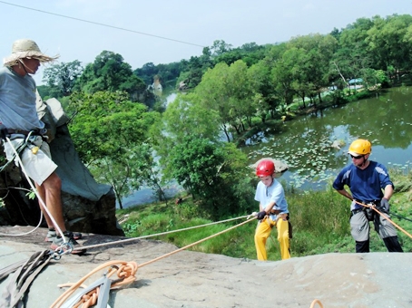 Một học sinh lớp 5 người nước ngoài (giữa) đang tập leo núi tại Khu du lịch Bửu Long.