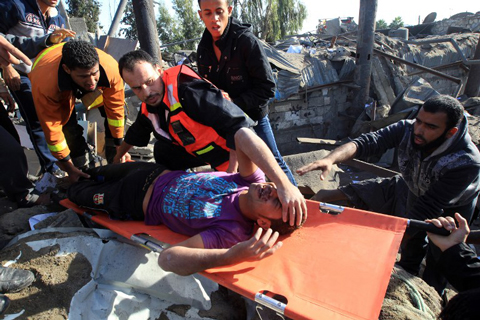 Một người đàn ông được đưa ra khỏi căn nhà bị sập tại dải Gaza sau đợt không kích của Israel.
