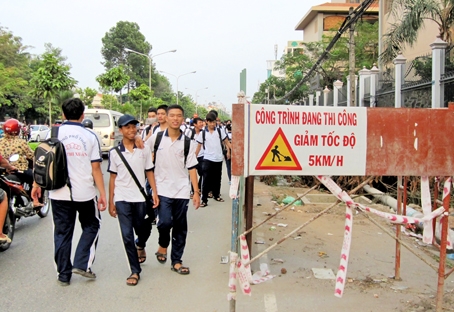 “Lô cốt” chiếm vỉa hè và một phần đường khiến học sinh Trường TH - THCS - THPT Bùi Thị Xuân ra về phải đi chung với xe cộ.