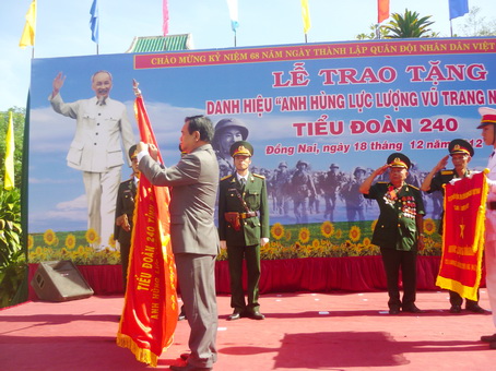 Đồng chí Trần Đình Thành gắn danh hiệu Anh Hùng lực lượng vũ trang lên lá cờ truyền thống của Tiểu đoàn 240.