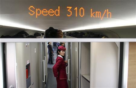 An attendant stands inside a high-speed train during an organized experience trip from Beijing to Zhengzhou, as part of a new rail line, December 22, 2012. China will open the world's longest high-speed rail line next week when a link between Beijing and the southern metropolis of Guangzhou is inaugurated, officials said on Saturday. 