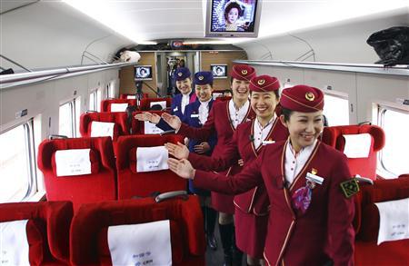 Attendants pose for pictures inside a high-speed train during an organized experience trip from Beijing to Zhengzhou, as part of a new rail line, December 22, 2012. China will open the world's longest high-speed rail line next week when a link between Beijing and the southern metropolis of Guangzhou is inaugurated, officials said on Saturday. 