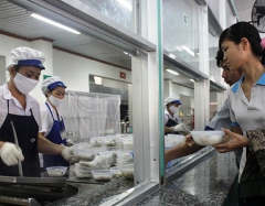 The workers of Taekwang Vina purchase their VND2,000 breakfast at the dining room ogf the company 